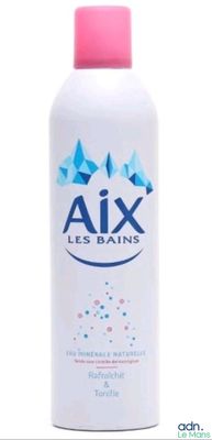 un gros plan d'un flacon de lotion posé sur une surface blanche