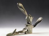 a sculpture of a rabbit sitting on top of a block of wood