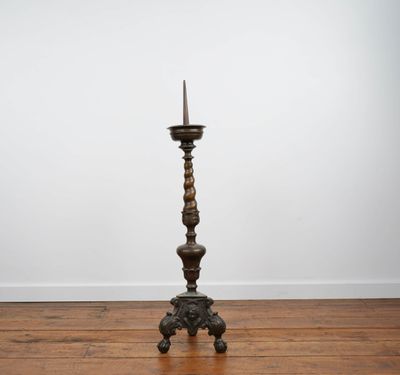 an antique wooden candle stand with a candle on top of it