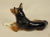 a figurine of a dog laying down on the ground