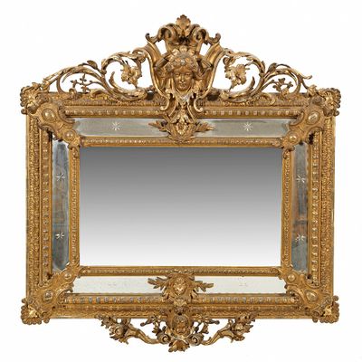 an ornately carved mirror with a gold frame on a white background