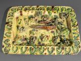 une assiette verte et jaune décorée de poissons et de plantes