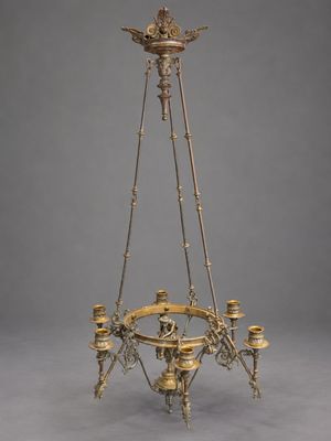 un lustre en laiton à quatre bougies, surmonté d'un oiseau
