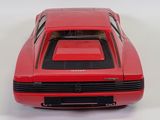 a red toy car that is sitting on a white surface