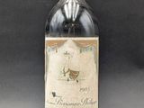 an old bottle of wine sitting on top of a table