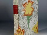an old book with a yellow flower on it sitting on a table