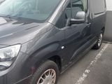 a grey van parked in a parking lot next to a traffic cone