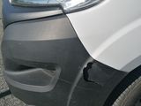 the front end of a white van parked in a parking lot