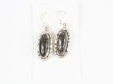 une paire de boucles d'oreilles en argent ornées d'une pierre noire au centre