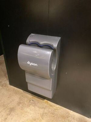 a toilet paper dispenser attached to a black wall