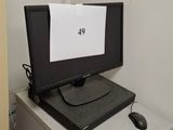 a computer monitor sitting on top of a filing cabinet