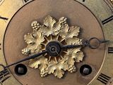 a gold clock with roman numerals on the face