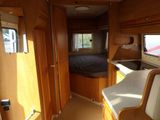 a view of a bedroom in a camper with a bed and a sink