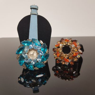 two watches and a bracelet sitting on a table