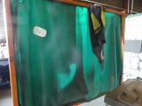 a green curtain hanging from the ceiling in a room