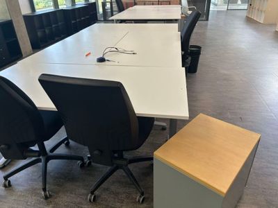 des tables et des chaises dans un bureau avec vue sur l'extérieur