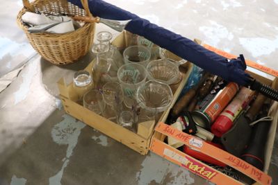 une boîte de verres vides et un parapluie par terre