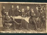 une vieille photo montrant un groupe d'hommes assis autour d'une table