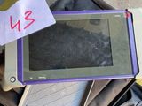 a purple and white laptop sitting on top of a black bag