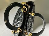 black and gold handbag on a white surface with a white background