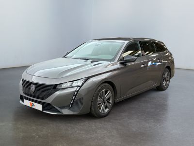 une voiture grise garée dans une pièce aux murs blancs