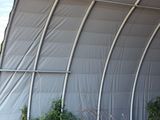 a large metal structure with a metal roof on the side of the building