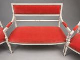 a pair of red upholstered chairs with white trim