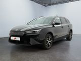Une voiture grise est garée dans une grande pièce aux murs blancs.