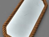 miroir dont le pourtour est entouré d'une corde, posé sur une surface grise