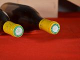two bottles of wine sitting on a red cloth
