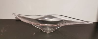 a glass bowl sitting on a table with a white wall in the background