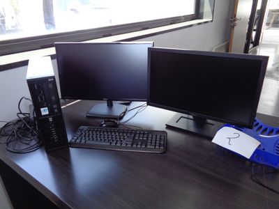 un bureau sur lequel sont posés deux écrans d'ordinateur et un clavier