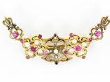 a close up of a necklace with pink stones and pearls