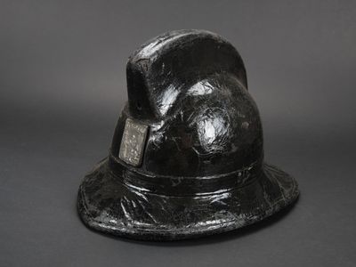un chapeau noir muni d'une étiquette, posé sur une table