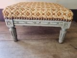 a small bench with a patterned seat on it
