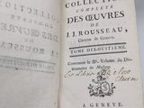 un livre ouvert sur une table, avec une pile de livres en arrière-plan