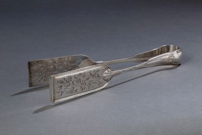 une cuillère en argent et une cuillère à manche posées sur une table