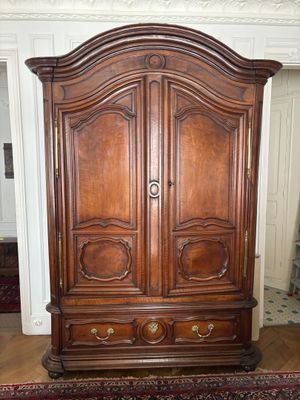 une grande armoire en bois au milieu d'une pièce