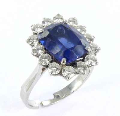 a close up of a blue sapphire and diamond ring on a white background