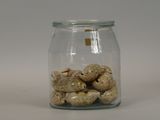 dried donuts in a glass jar on a white surface