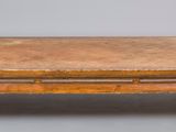 une vieille table basse en bois avec un plateau en cuir sur fond gris
