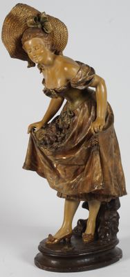 figurine en bronze représentant une femme coiffée d'un chapeau et tenant un panier de fleurs