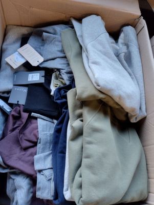 une boîte pleine de vêtements posée sur le sol