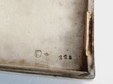 an old metal tray with a handle on a white surface