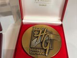 a gold medal in a red box on a table