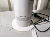a white electric fan sitting on top of a white table
