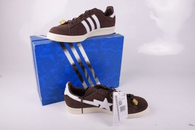 Chaussures adidas Superstar marron et blanches, présentées dans une boîte bleue