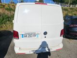a white van parked in a parking lot next to a black car