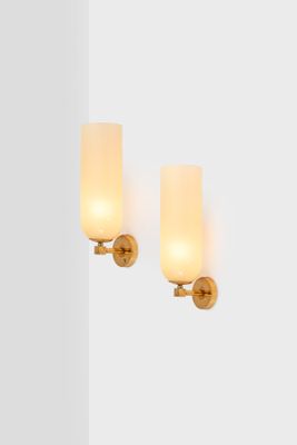 pair of brass sconces with frosted glass shades