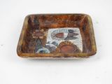 a small tray with a picture on it on a white surface